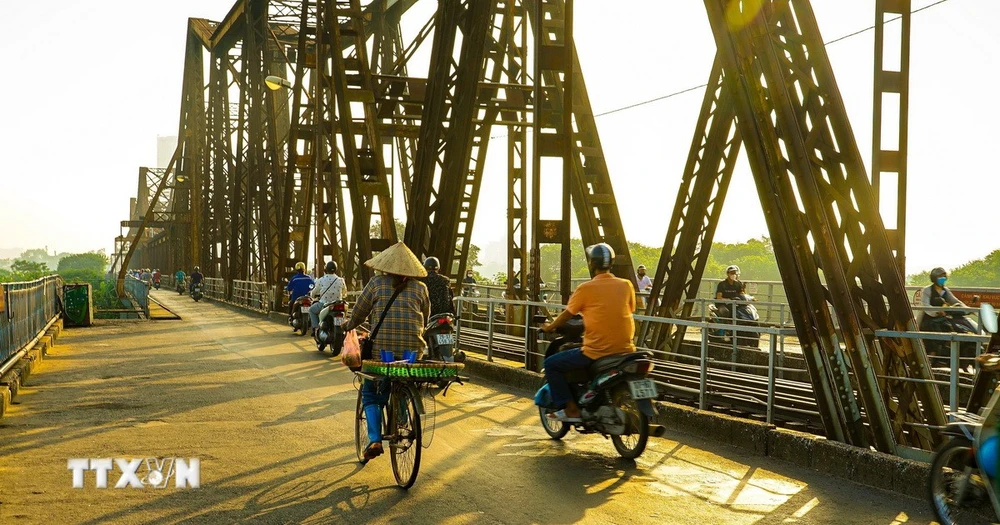 Cầu Long Biên cổ kính dường như cũng trở nên mộng mơ dưới những tia nắng vàng óng. (Ảnh: Khánh Hòa/TTXVN)