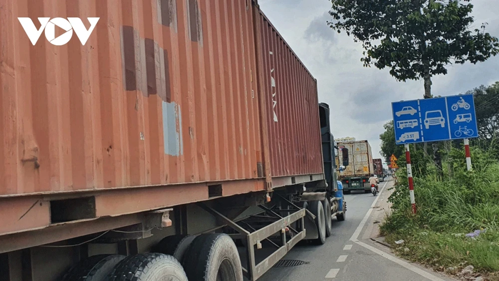 Mặc dù đã có biển báo phân làn, nhưng xe container vẫn... lấn làn (ảnh: Thiên Lý)