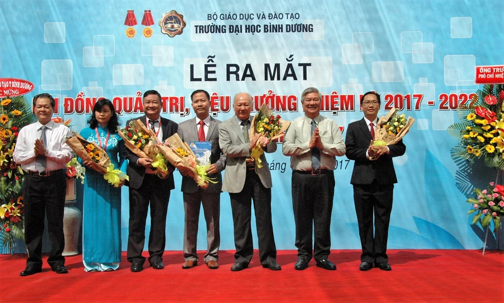 Ông Đặng Minh Hưng (thứ 2, từ phải) tặng hoa chúc mừng Ban Giám hiệu