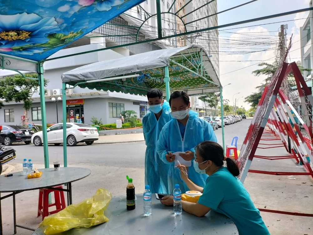 Lực lượng y tế làm nhiệm vụ truy vết các trường hợp tiếp xúc gần tại một chung cư ở TP Thuận An