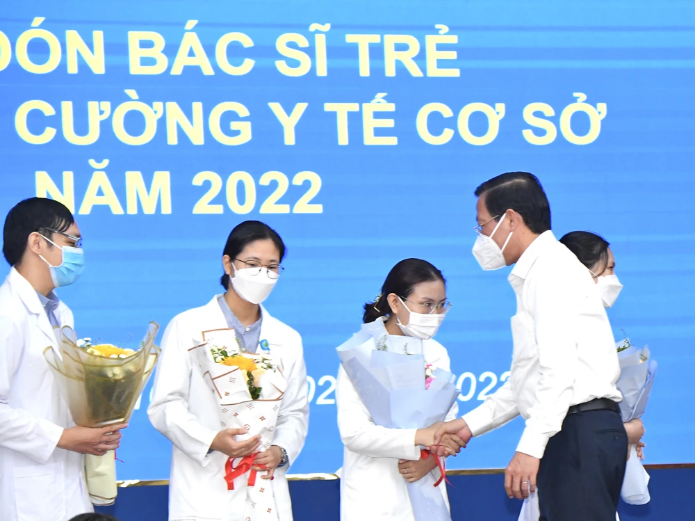 Chủ tịch UBND TPHCM Phan Văn Mãi chúc mừng các bác sĩ trẻ tăng cường về trạm y tế cơ sở. Ảnh: VIỆT DŨNG