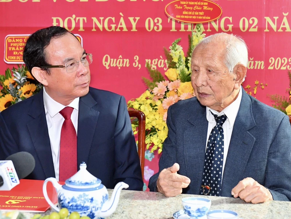 Bí thư Thành ủy TPHCM thăm hỏi, trò chuyện với đồng chí Lê Văn Triết tại lễ trao tặng Huy hiệu 75 năm tuổi Đảng. Ảnh: VIỆT DŨNG