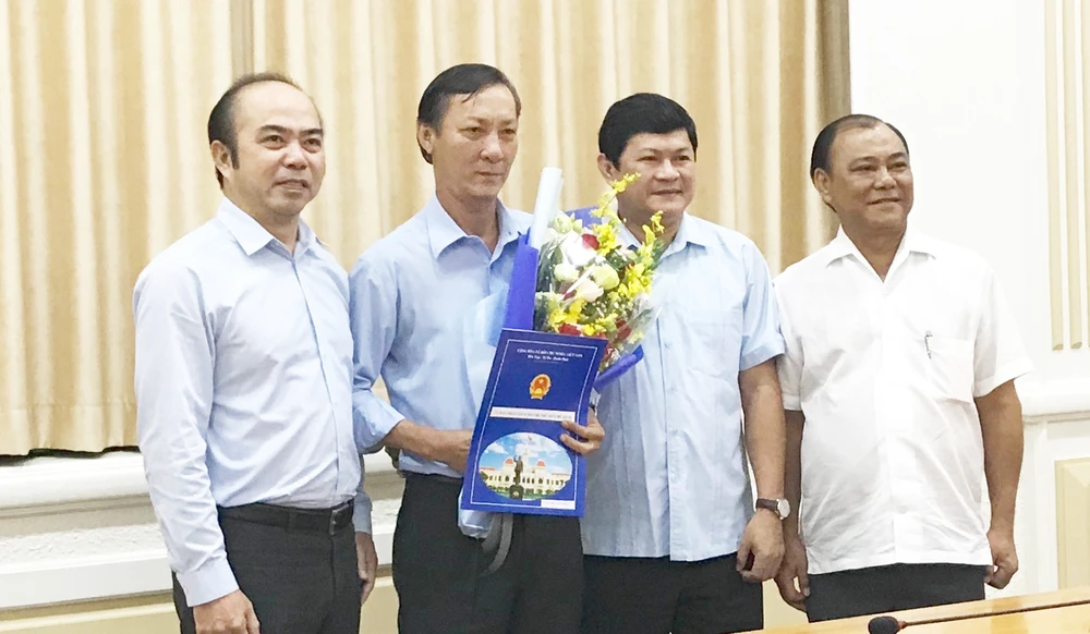 Phó Chủ tich UBND TPHCM Huỳnh Cách Mạng (thứ hai từ phải sang) và ông Hồ Văn Ngon (thứ ba từ phải sang) tại buổi trao quyết định. Ảnh: KIỀU PHONG
