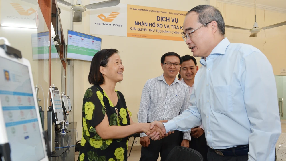 Bí thư Thành uỷ TPHCM Nguyễn Thiện Nhân thăm hỏi người dân về dịch vụ hành chính công tại UBND quận Bình Thạnh. 