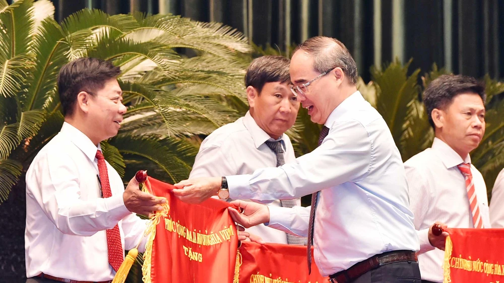 Đồng chí Nguyễn Thiện Nhân, Bí thư Thành ủy TPHCM, trao cờ thi đua chính phủ cho các tập thể. Ảnh: VIỆT DŨNG