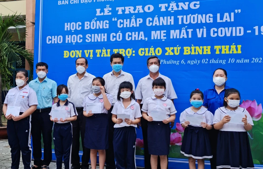 Trao tặng học bổng “chắp cánh tương lai” cho học sinh có cha, mẹ mất vì Covid-19 và các em có hoàn cảnh khó khăn ở phường 6, quận 8. Ảnh: MẠNH HOÀ