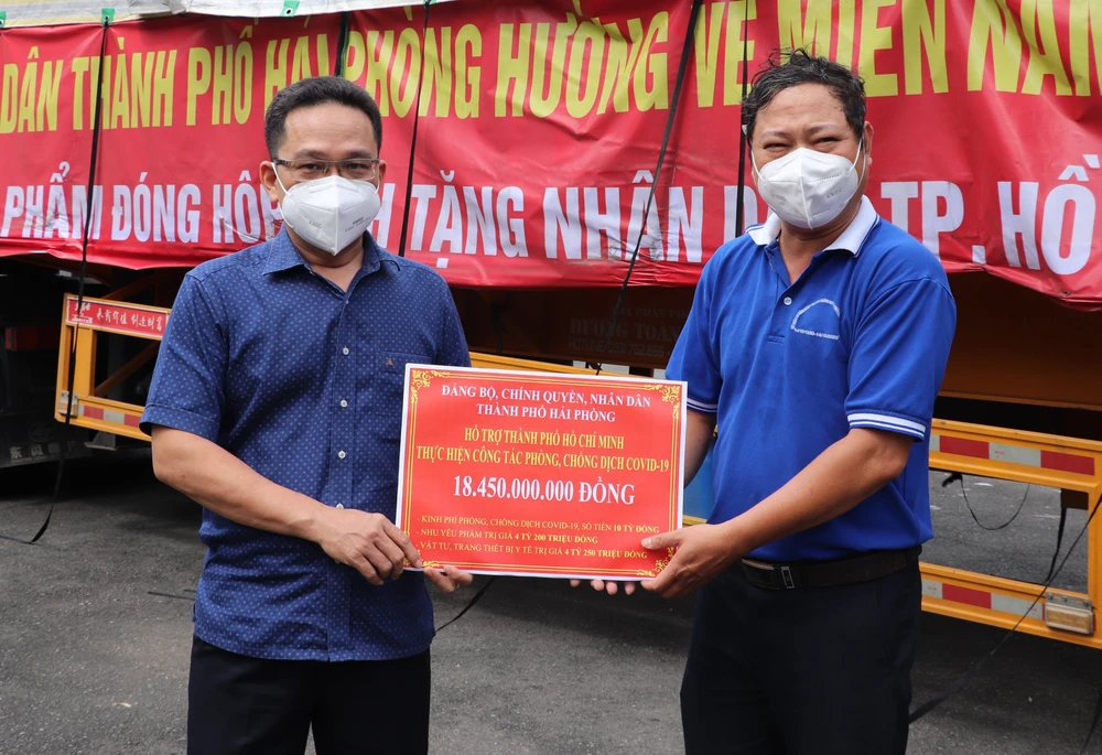 Phó Chủ tịch Ủy ban MTTQ Việt Nam TPHCM Phạm Minh Tuấn tiếp nhận bảng tượng trưng ủng hộ từ TP Hải Phòng