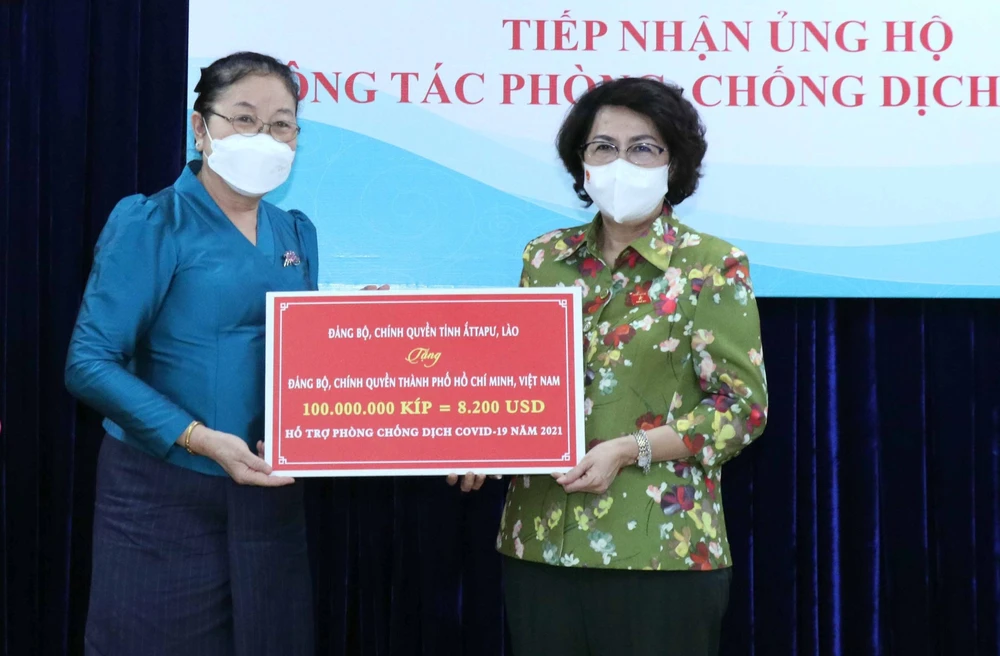 Chủ tịch Ủy ban MTTQ Việt Nam TPHCM Tô Thị Bích Châu tiếp nhận bảng tượng trưng ủng hộ do tỉnh Attapeu, Lào trao tặng