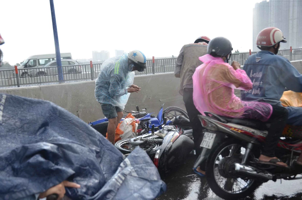 Người dân lưu thông trên cầu té ngã vì đường trơn trượt trong cơn mưa lớn. Ảnh: C.T