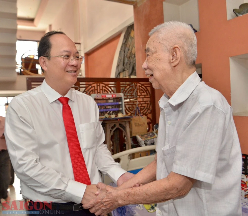Phó Bí thư Thành ủy TPHCM Nguyễn Hồ Hải ân cần hỏi thăm sức khỏe cụ Lục Nghĩa. Ảnh: CAO THĂNG