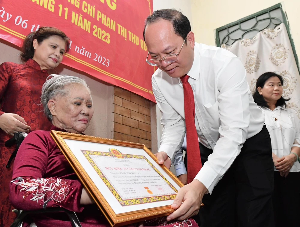 Phó Bí thư Thành ủy TPHCM Nguyễn Hồ Hải trao Huy hiệu 75 năm tuổi Đảng cho đồng chí Phan Thị Thu Quỳ. Ảnh: VIỆT DŨNG 