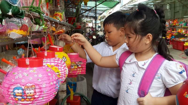 兒童在梁汝學街陳富店選購花燈。
