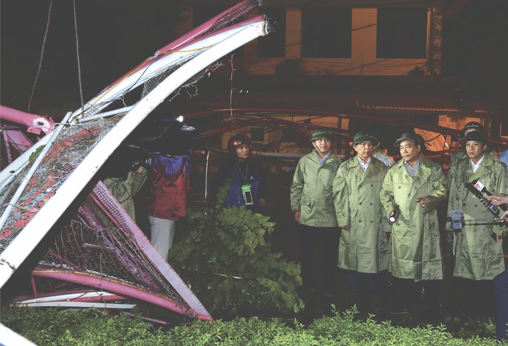 政府總理阮春福（右二）視察廣平省指導災後恢復生活生產工作。