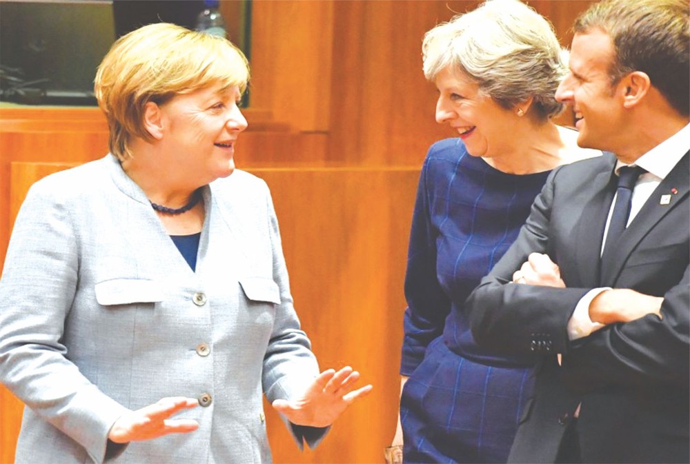 英首相特蕾莎‧梅（中）與德總理默克爾（左）及法國總統馬克龍言談甚歡。