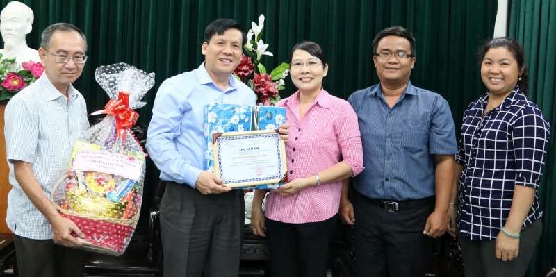 本報主編阮玉英(左二) 和范興主任接受代表團贈送禮物和感謝書。