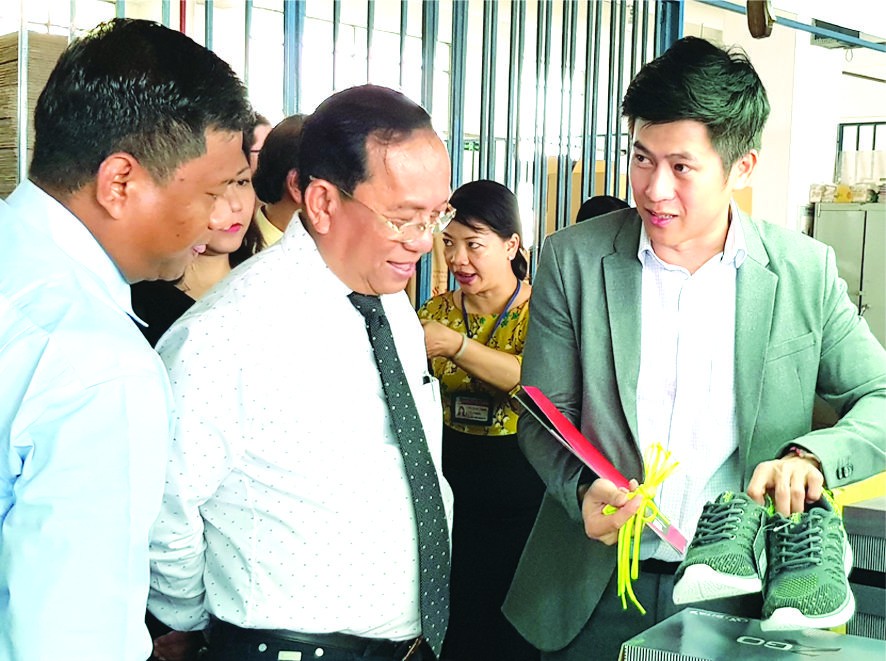 張傳發經理(右)向緬甸代表團介紹平新鞋品。