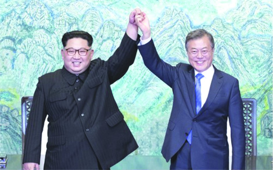 韓總統文在寅(右)與朝國務委員會委員長金正恩牽手舉臂。