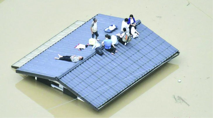 民眾爬上屋頂等 待救援。