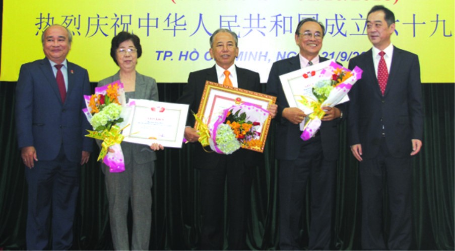 市各友好組織聯合會主席黃明善(左一)和 中國駐本市總領事吳駿(右一)祝賀獲表彰的集 體與個人。