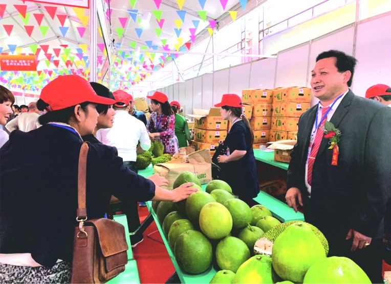 陳榮森（右）向中國消費者推介越南水果。