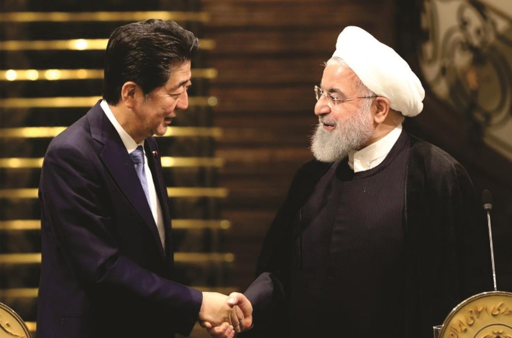 日本首相(左)與伊朗最高領導人握手。
