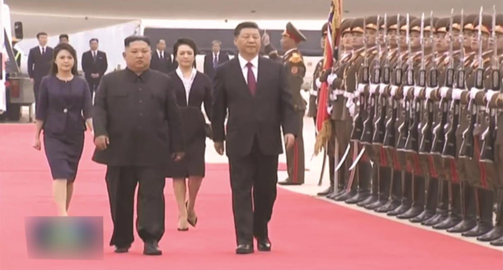 金正恩（左）和習近平在機場檢閱朝鮮人民軍儀仗隊。