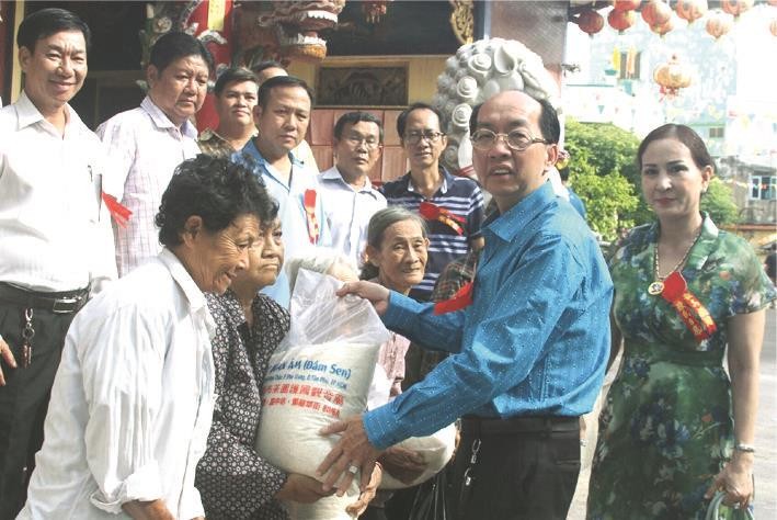 該廟理事長黃偉峰和夫人阮氏日鳳向貧困者派發大米。