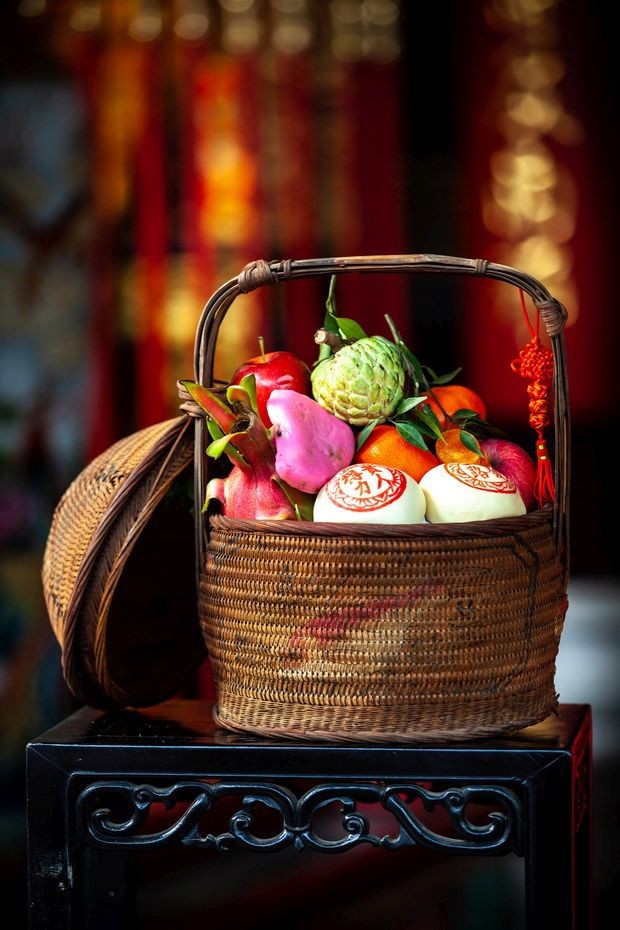 何月紅女士用百年潮州花籃放著各種供品帶到堤岸關帝廟 酬神。