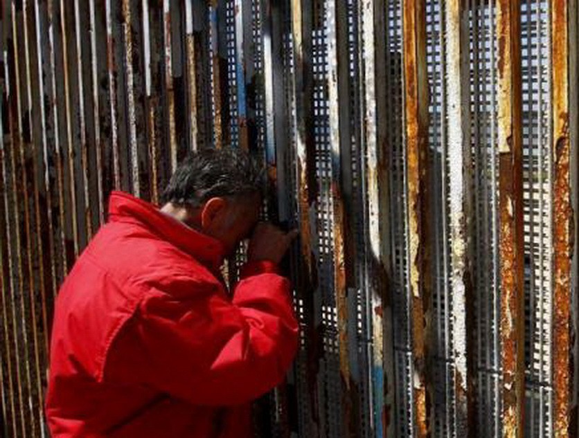 墨西哥提華納，移民家庭隔著美墨邊境之間的隔離牆聊天。（圖源：互聯網） 
