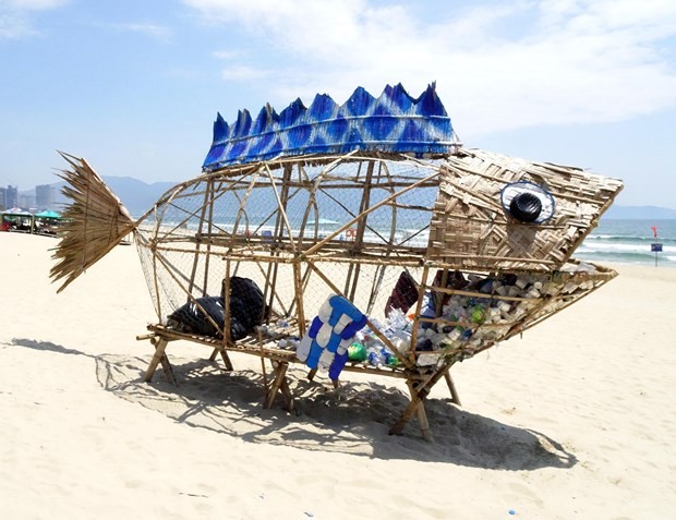 峴港市美溪海灘上用竹、椰子葉和回收材料製成的魚模型垃圾桶。
