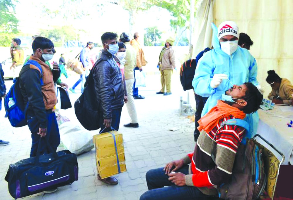 乘客在印度德里一處巴士終點站接受新冠病毒檢測取樣。