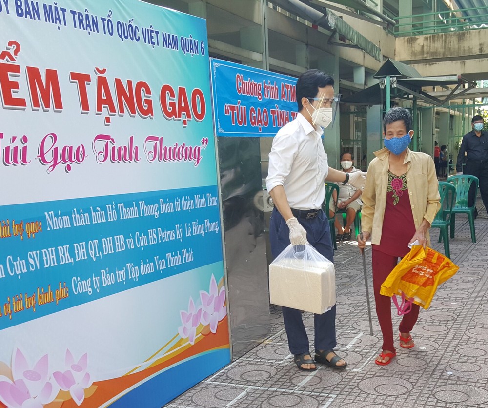 第六郡越南祖國陣線委員會主席阮國洋向貧困者贈送大米。