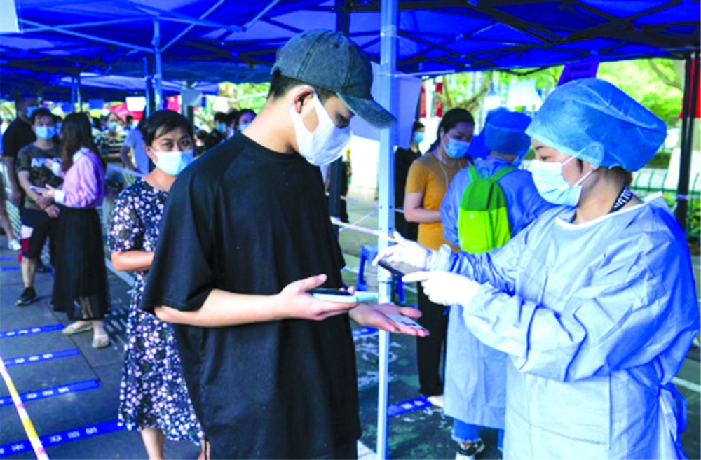 在南京市北門橋社區核酸檢測點，工作人員在用手機掃描市民身份證信息。