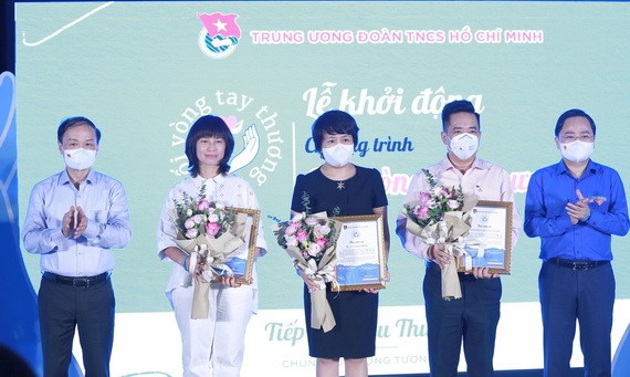 中央民運部常務副部長范必勝（左）和共青團中央第一書記阮英俊 向計劃贊助商送花。