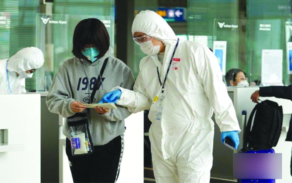 韓國仁川機場，航空公司工作人員檢查旅客防疫證明等。