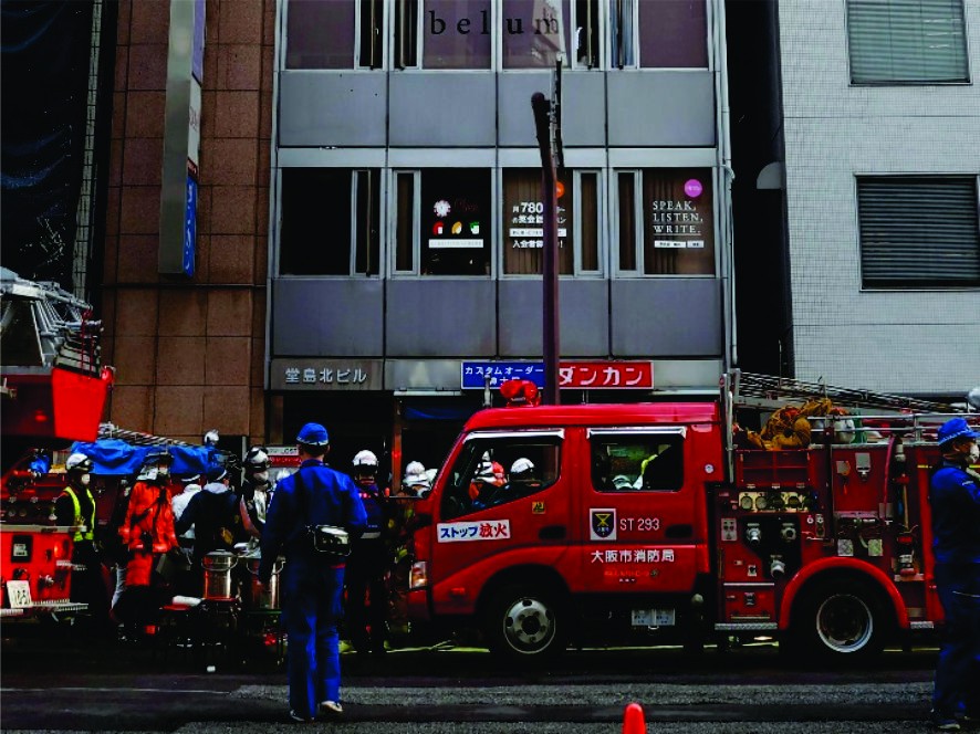 消防員在日本大阪市火災現場附近工作。