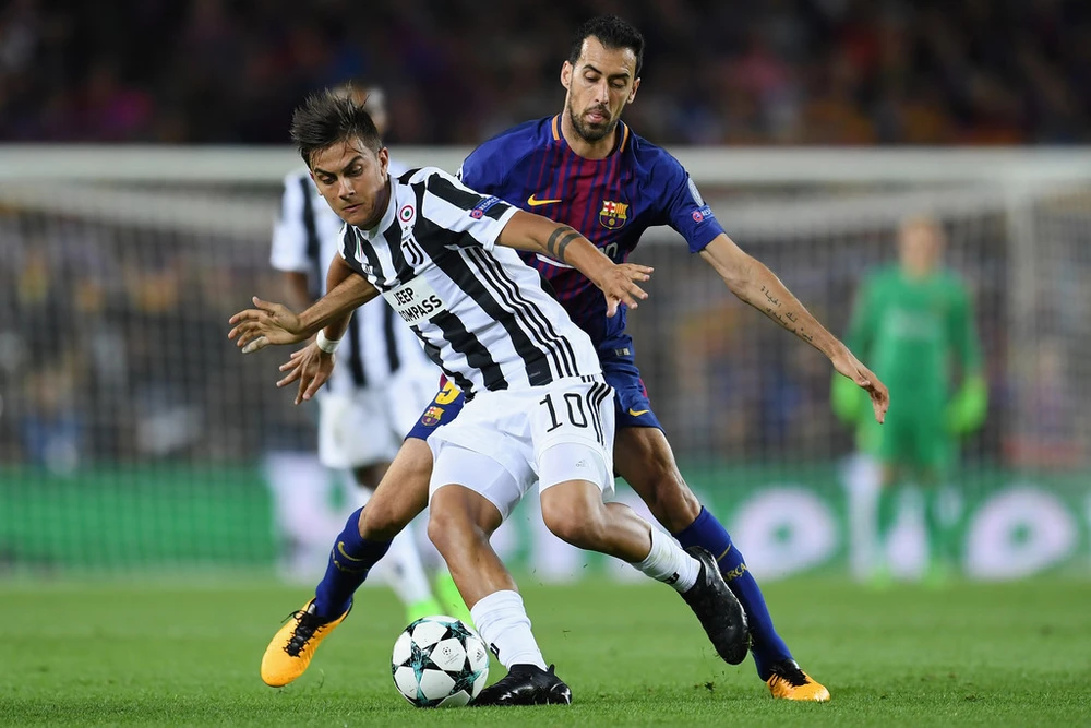 Paulo Dybala (Juventus) đi bóng trước Sergio Busquets (Barcelona). Anh: Getty Images.