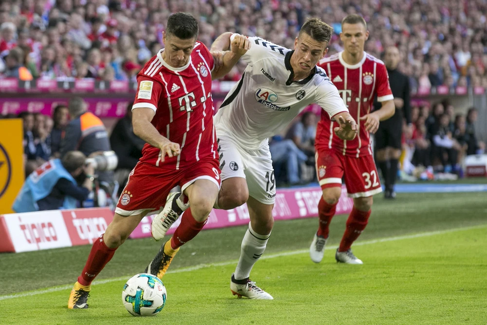 Robert Lewandowski (trái, Bayern) d09i bóng qua hậu vệ Janik Haberer (Freiburg). Ảnh: Getty Images.