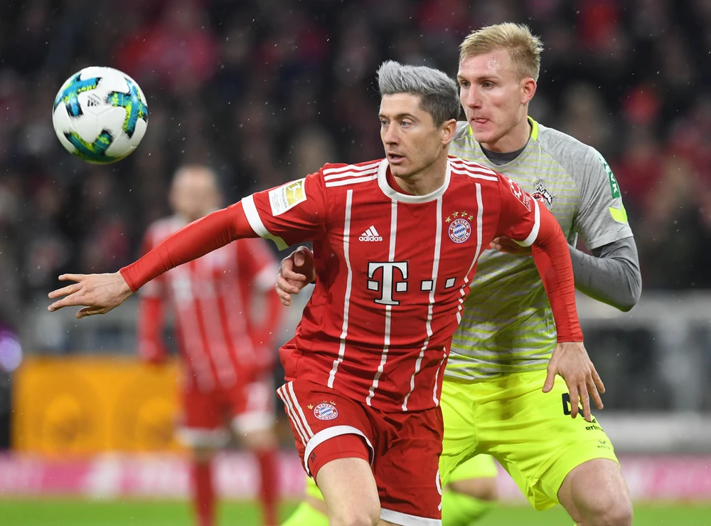 Tiền đạo Robert Lewandowski (trái, Bayern Munich) tranh bóng với hậu vệ Cologne. Ảnh: Getty Images.