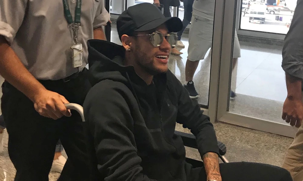 Neymar về đến Rio De Janeiro trên xe lăn.