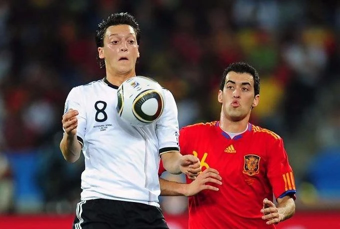 Mesut Oezil (trái, tuyển Đức) tranh bóng với Sergio Busquets (Tây Ban Nha). Ảnh: Getty Images.