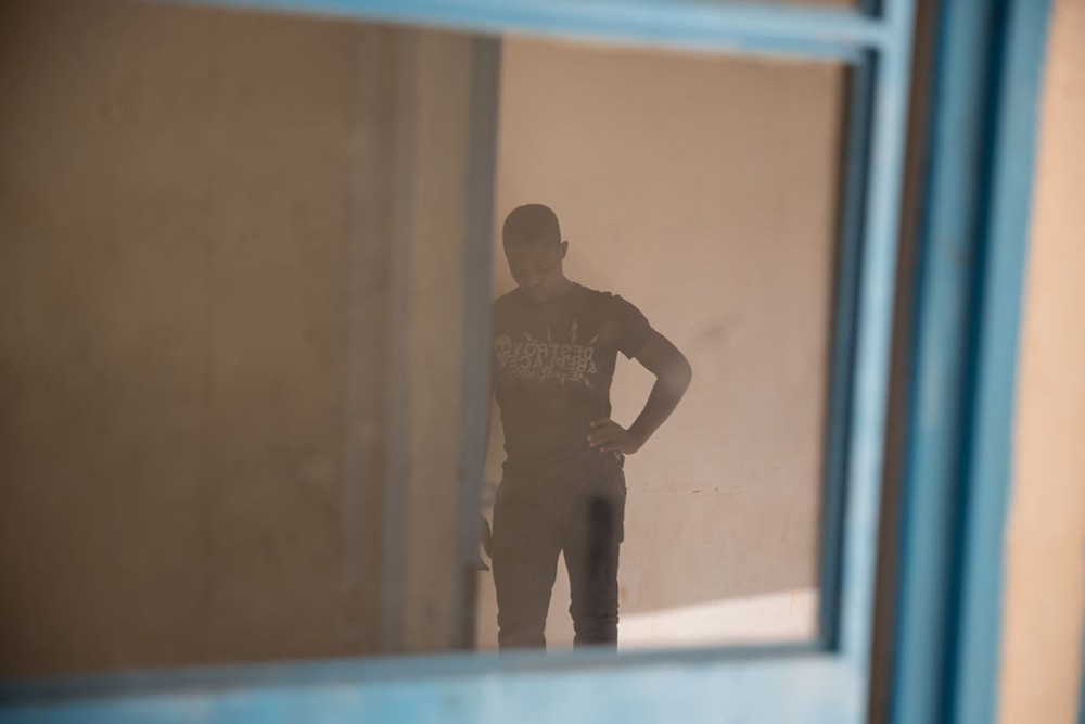 一個年輕人在尼日爾阿加德茲的一處過境中心等待。他與他的弟弟在嘗試逃到歐洲失敗後返回國內。（圖片來源：聯合國新聞）