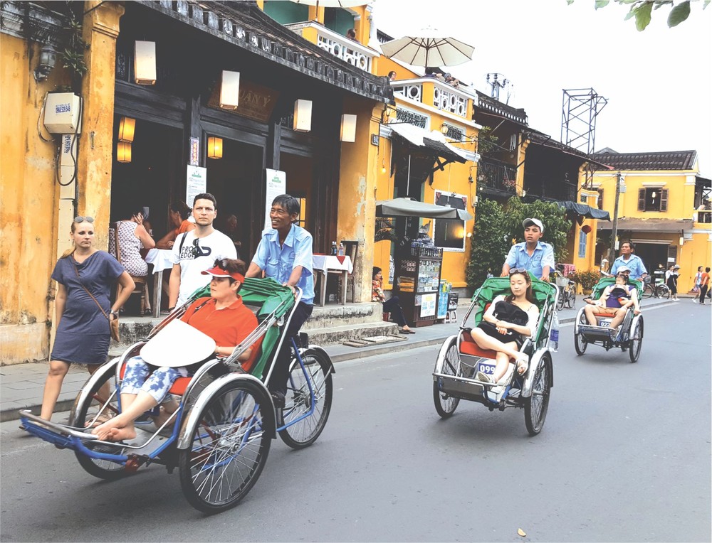 國際遊客乘坐三輪車參觀會安古埠。