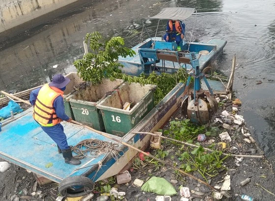 Thu gom rác trên kênh Tân Hóa - Lò Gốm, khu vực quận Tân Phú (ảnh chụp ngày 6-6)