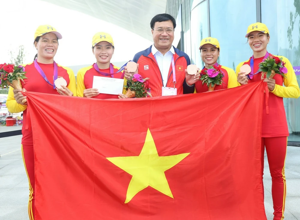 Đội rowing giành HCĐ và được lãnh đạo Đoàn thể thao Việt Nam thưởng "nóng" khích lệ. Ảnh: LƯỢNG LƯỢNG