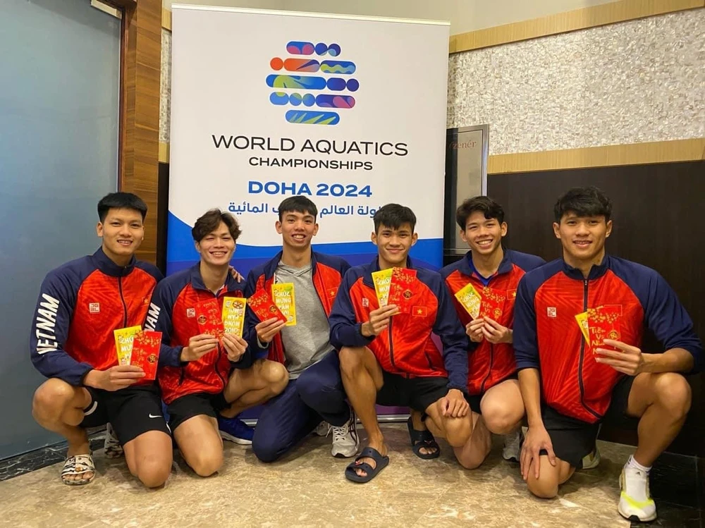 Nguyễn Huy Hoàng (giữa) cùng đồng đội được mừng tuổi năm mới ngay khi đang dự tranh giải bơi vô địch thế giới 2024 lúc này. Ảnh: VASA