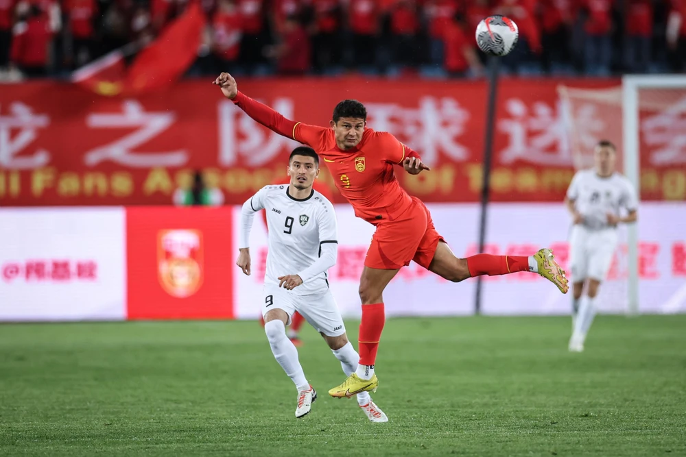 Tiền đạo nhập tịch Trung Quốc Ai Kesen tranh bóng với cầu thủ Uzbekistan