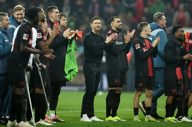 HLV Xabi Alonso ăn mừng cùng toàn đội Leverkusen sau chiến thắng Bayern Munich