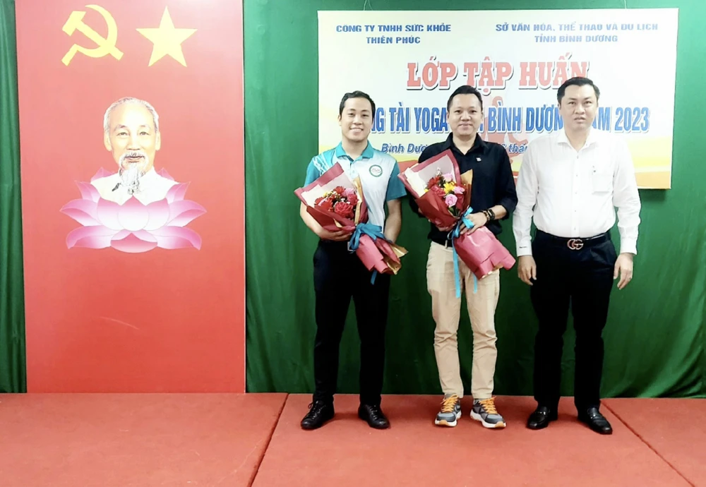 Ông Cao Văn Chóng – PGĐ Sở VH-TT&DL tỉnh Bình Dương tặng hoa và chụp hình lưu niệm cùng các giảng viên đến từ Liên đoàn Yoga Việt Nam