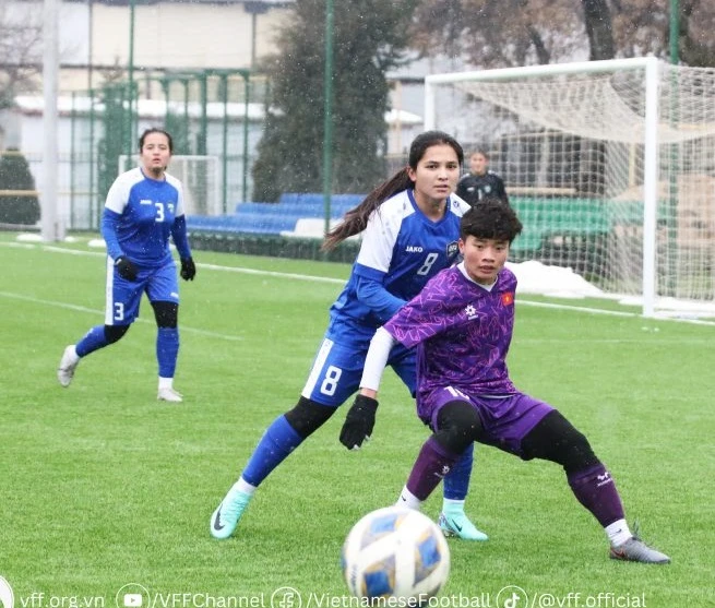 Ngọc Minh Chuyên tranh bóng cùng cầu thủ đội chủ nhà